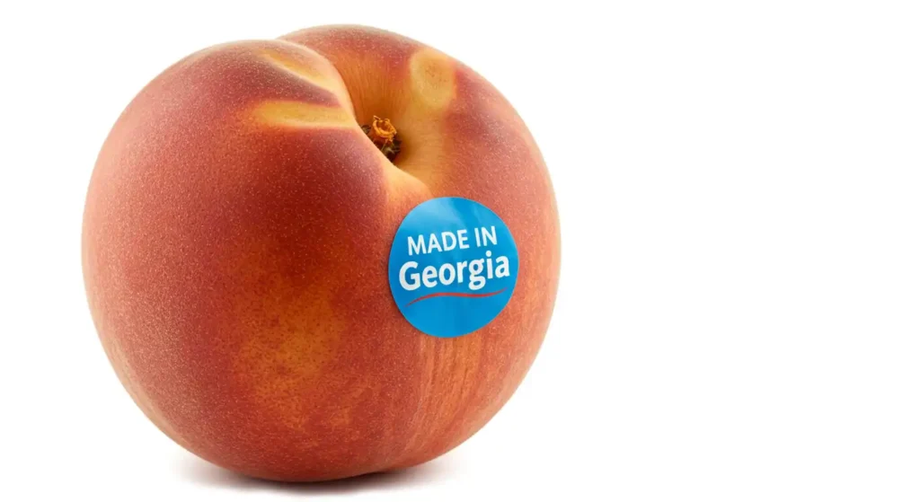 A Georgia peach with a blue "Made in Georgia" sticker