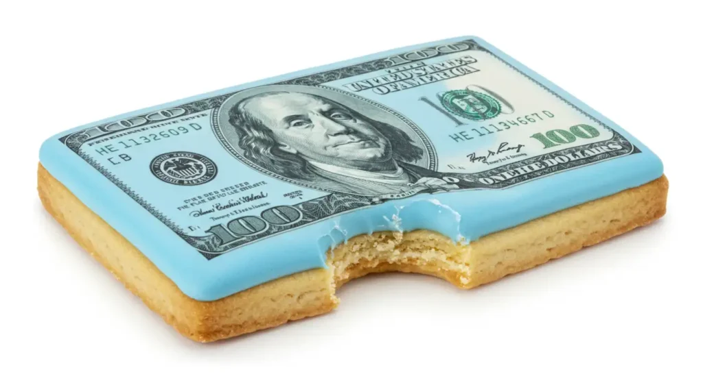 A cookie with USD icing and a bite out of it